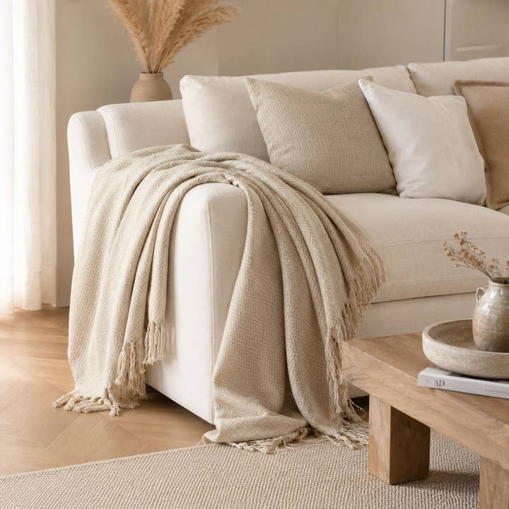 Beiglow sofaplagg | Sandsteinsbeige | Håndvevd bomull i fiskebeinmønster | Frynser | 130×150 cm | Urbane Hide