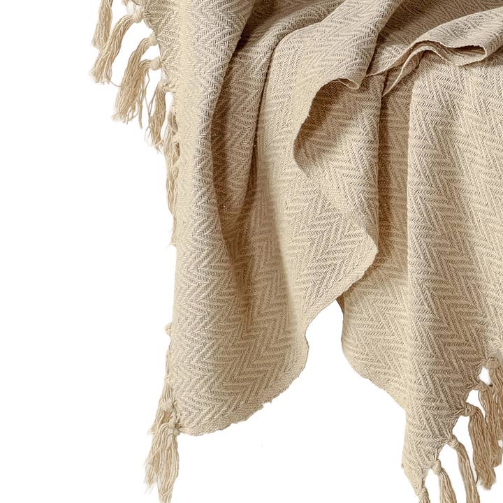 Beiglow sofaplagg | Sandsteinsbeige | Håndvevd bomull i fiskebeinmønster | Frynser | 130×150 cm | Urbane Hide