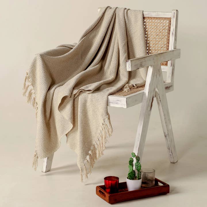 Beiglow sofaplagg | Sandsteinsbeige | Håndvevd bomull i fiskebeinmønster | Frynser | 130×150 cm | Urbane Hide